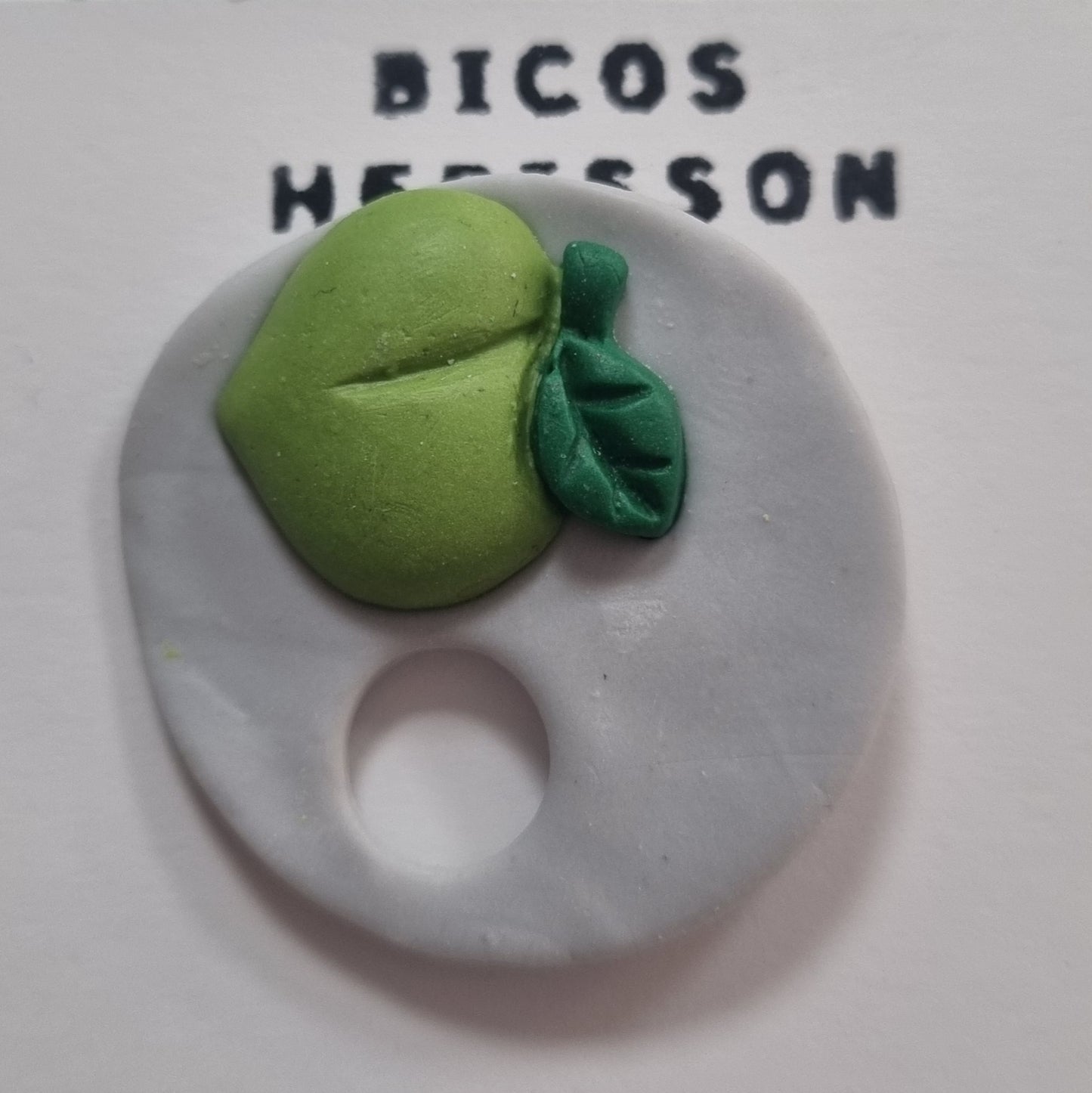 Broche cuelga gafas manzana